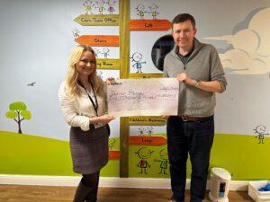Mike Prendergast presents a cheque for £1,000 to Derian House